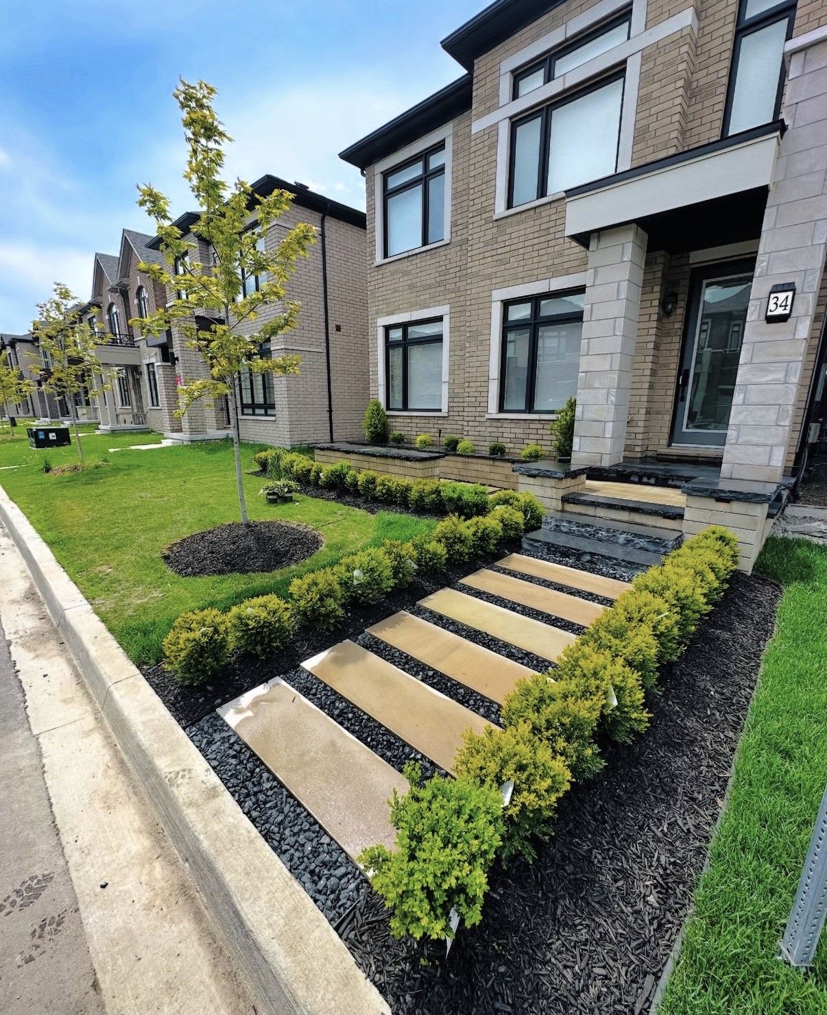 Front entrance with large slab stepping stones and boxwood hedging